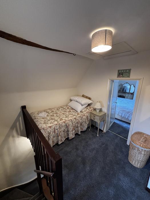 Single bed by the staircase